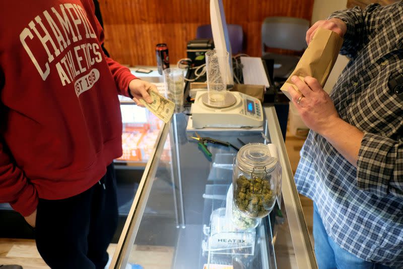 FILE PHOTO: An employee measures from a jar of marijuana on sale at the Greenstone Provisions in Ann Arbor