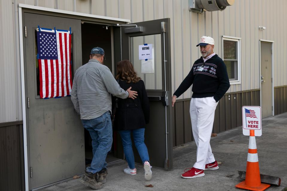 Precinct Election Official Keith Mendenhall holds the door open for voters as they enter the Berne Township Fire Department on Election Day on Mar. 19, 2024, in Sugar Grove, Ohio.