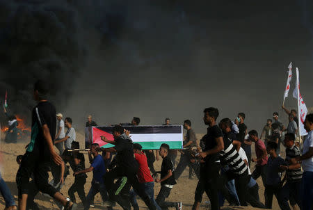 Palestinian demonstrators run during clashes with Israeli troops at a protest demanding the right to return to their homeland at the Israel-Gaza border, in the southern Gaza Strip August 3, 2018. REUTERS/Ibraheem Abu Mustafa