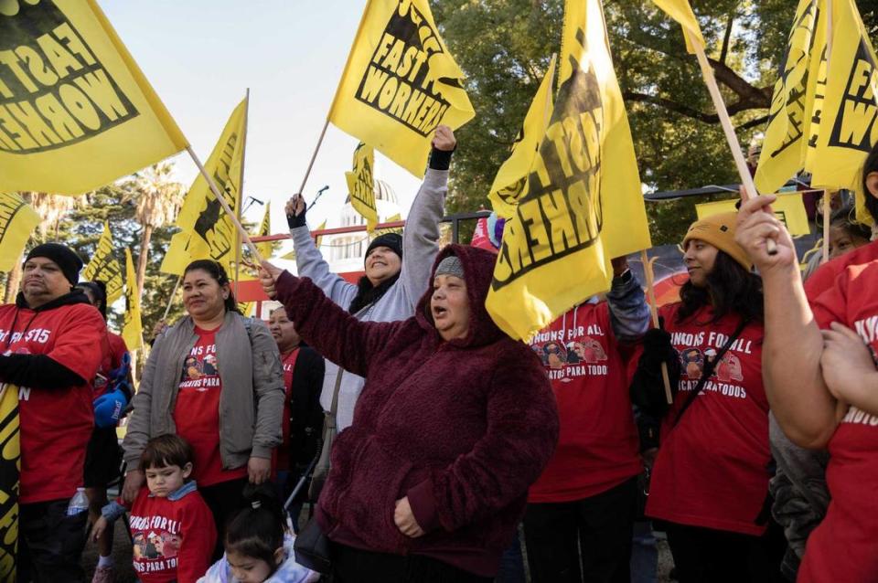 Sandra Jauregui, center, and other fast-food workers rally at the state Capitol in November 2022, demanding that fast food companies stop seeking to repeal a bill creating a fast food council to improve workplace conditions. Bill author Assemblyman Chris Holden is pushing another measure that would hold corporations liable for employee mistreatment.
