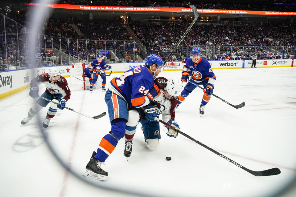 New York Islanders defenseman Scott Mayfield (24) and Colorado Avalanche's Alex Newhook (18) battle for the puck in the first period of an NHL hockey game, Saturday, Oct. 29, 2022, in Elmont, N.Y. (AP Photo/Eduardo Munoz Alvarez)