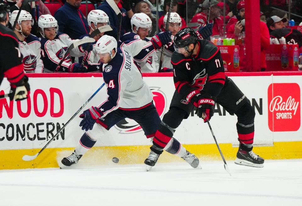 Apr 7, 2024; Raleigh, North Carolina, USA; Columbus Blue Jackets center Cole Sillinger (4) and Carolina Hurricanes center Jordan Staal (11) battle over the puck during the second period t PNC Arena. Mandatory Credit: James Guillory-USA TODAY Sports