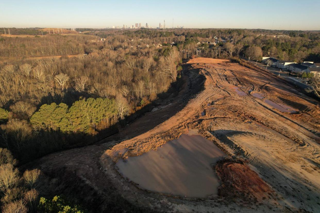 Bulldozed land at the planned site of a controversial police training facility, with Atlanta in the distance. <a href="https://www.gettyimages.com/detail/news-photo/section-of-bulldozed-land-is-seen-at-the-planned-site-of-a-news-photo/1246850758" rel="nofollow noopener" target="_blank" data-ylk="slk:Cheney Orr/AFP via Getty Images;elm:context_link;itc:0;sec:content-canvas" class="link ">Cheney Orr/AFP via Getty Images</a>