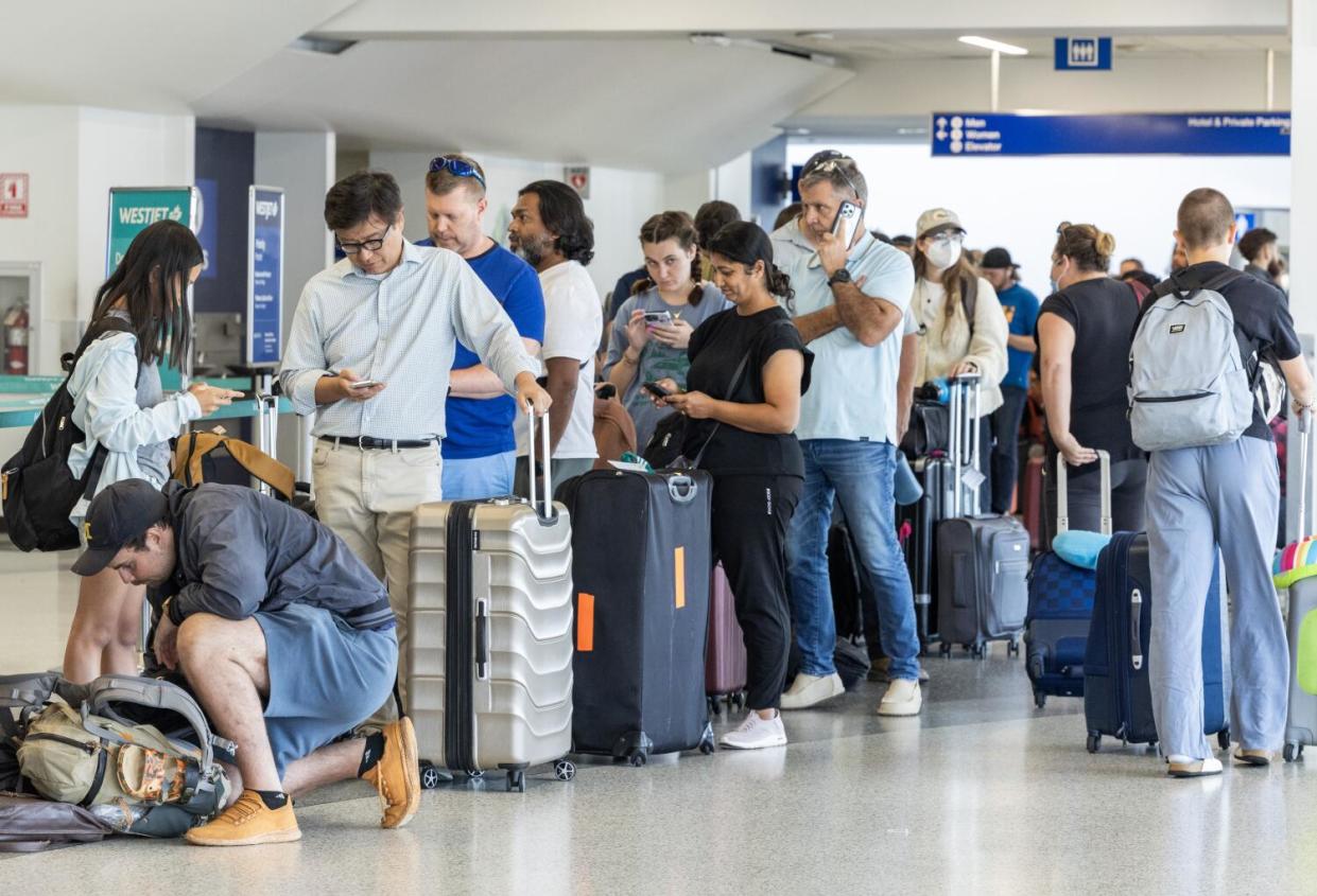 Delta passengers wait in line to re-book their flights on Friday, after LAX was affected by a global technology outage.