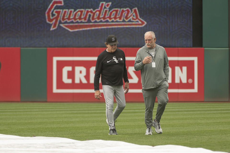 Chicago White Sox manager Tony LaRussa, left, and Ed Cassin, director of team travel walk in the outfield at Progressive Field while inspecting the field after a heavy rain before a baseball game against the Cleveland Guardians in Cleveland, Sunday, Aug. 21, 2022. (AP Photo/Phil Long)