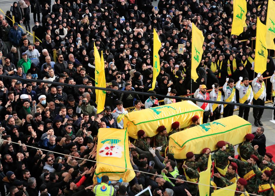 Hezbollah fighters carry the coffins of a comrade and two civilians who were killed by an Israeli airstrike that hit their house in Bint Jbeil, South Lebanon, on Dec. 27, 2023.