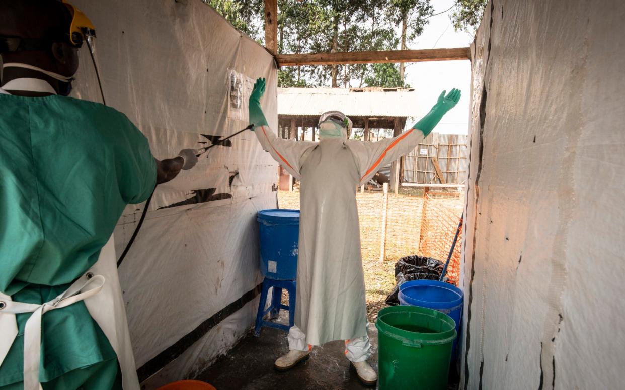 A health worker is hosed down after leaving an Ebola treatment centre - Simon Townsley
