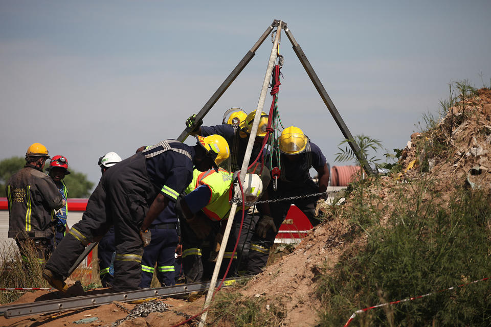 Emergency rescue workers attempt to free trapped illegal miners at a disused gold mine shaft near, Benoni, South Africa, Sunday, Feb. 16, 2014. The South African Press Association reported Sunday that rescue teams were able to speak to about 30 miners near the top of an old gold mine shaft whose entrance was covered by a large rock. Those miners said as many as 200 others were trapped further down a steep tunnel at the mine in Benoni, on the outskirts of Johannesburg (AP Photo)