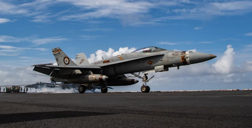 An F/A-18C Hornet from the VMFA-323 "Death Rattlers" makes an arrested landing on the flight deck of the USS Nimitz in 2021.