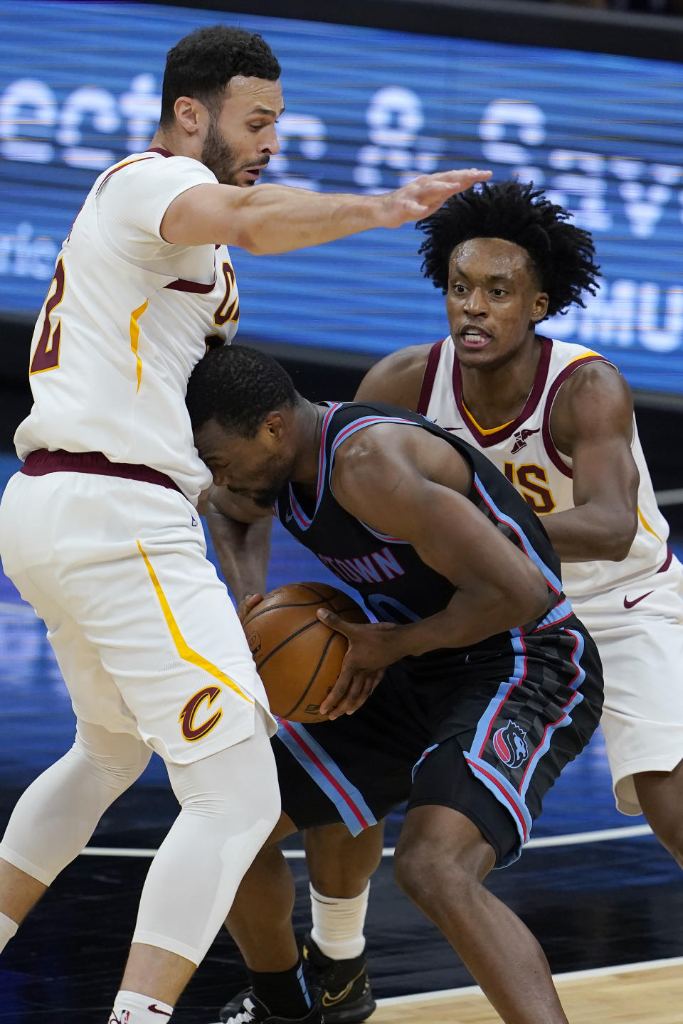 Sacramento Kings forward Harrison Barnes, middle, is defended by Cleveland Cavaliers forward Larry Nance Jr., left, and guard Collin Sexton during the first half of an NBA basketball game in Sacramento, Calif., Saturday, March 27, 2021. (AP Photo/Jeff Chiu)