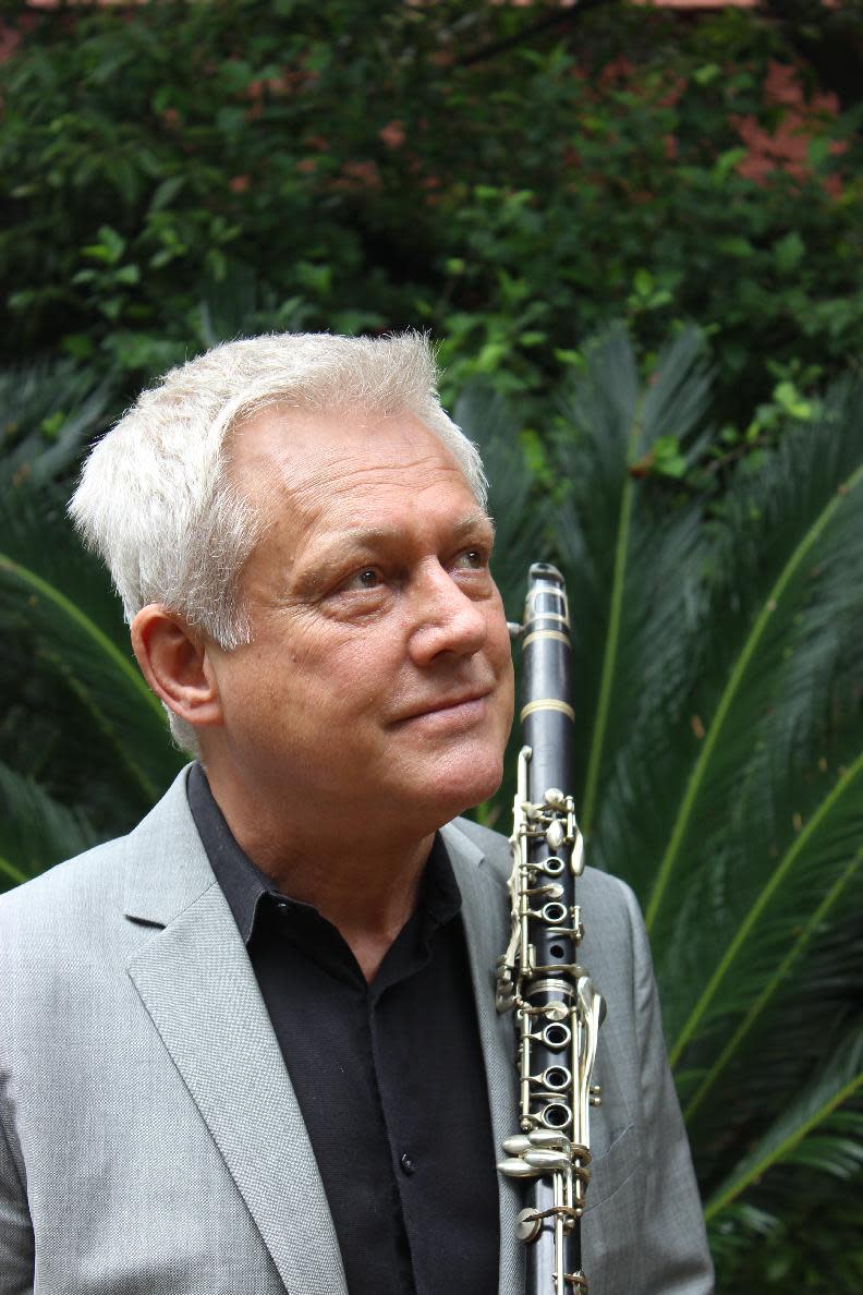 Jazz clarinetist Orange Kellin stands in the courtyard of his apartment in New Orleans' French Quarter on Thursday April, 24, 2014. Kellin played in the New Orleans Ragtime Orchestra at the first New Orleans Jazz and Heritage Festival 45 years ago in a Treme neighborhood park, and is performing with his own band at the 45th Jazz Fest. (AP Photo/Janet McConnaughey)