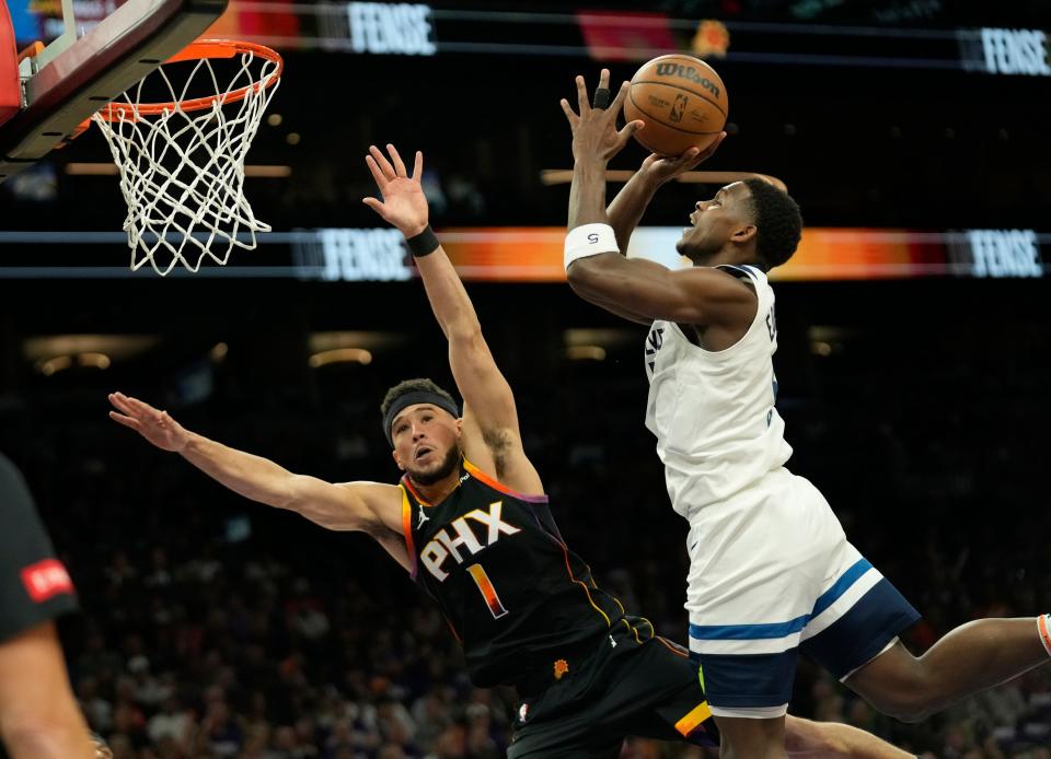 Phoenix Suns guard Devin Booker (1) defends Minnesota Timberwolves guard Anthony Edwards (5) during game 4 of the Western Conference first round series at Footprint Center on Sunday, April 28, 2024.