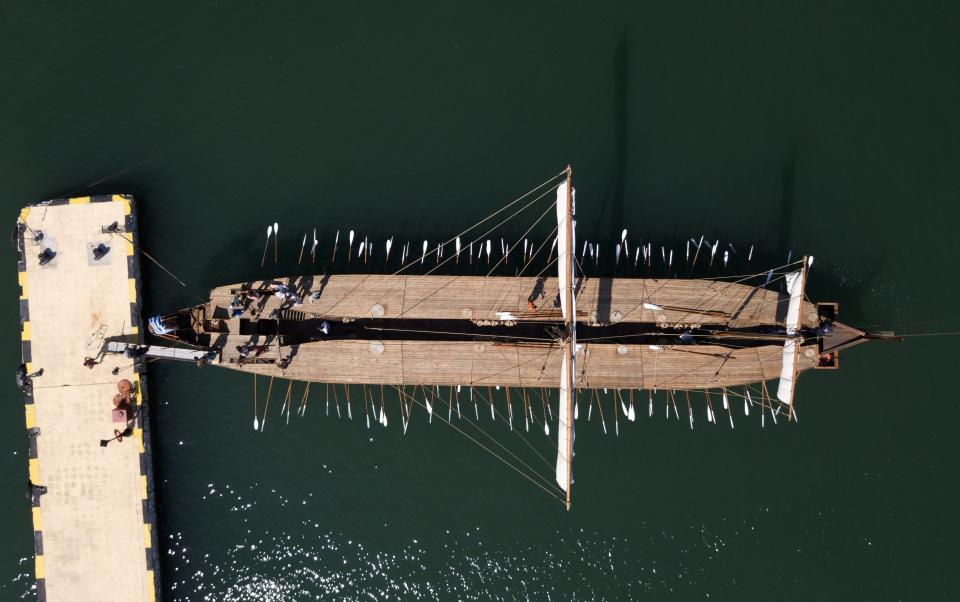 In this Sunday, Sept. 16, 2018 photo, Greece's Olympias, a replica of an ancient galley, is docked at Flisvos Marina in southern Athens. The 37-meter (121-foot) wooden vessel moored off southern Athens is an experimental reconstruction of the trireme, the sleek ancient Greek warship that halted a Persian invasion of Europe and ruled the Mediterranean for centuries. Every summer, visitors can get a whiff of life in the galleys 2,500 years ago by joining the crew of the Olympias _ and work up a sweat rowing it. (AP Photo/Thanassis Stavrakis)