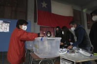 A woman votes at a polling station in Santiago, Chile, Sunday, Oct. 25, 2020. Amid a year of contagion and turmoil, Chileans vote Sunday on whether to draft a new constitution for their nation to replace guiding principles imposed four decades ago under a military dictatorship.(AP Photo/Esteban Felix)