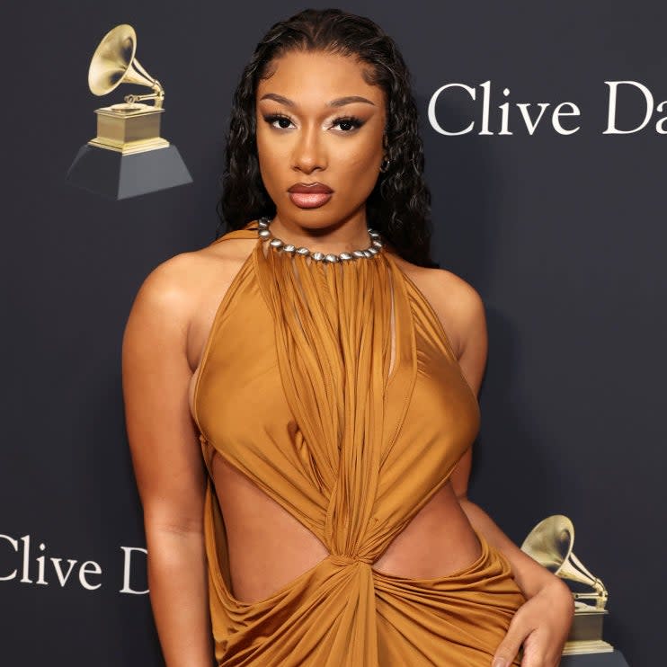 Megan Thee Stallion posing in an elegant gown with a knotted front at a Clive Davis event