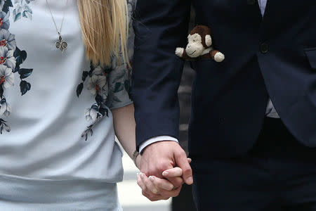 The father of critically ill baby Charlie Gard carries a toy monkey in his pocket as he and Connie Yates, Charlie Gards mother, arrive at the High Court in London, Britain July 14, 2017. REUTERS/Neil Hall