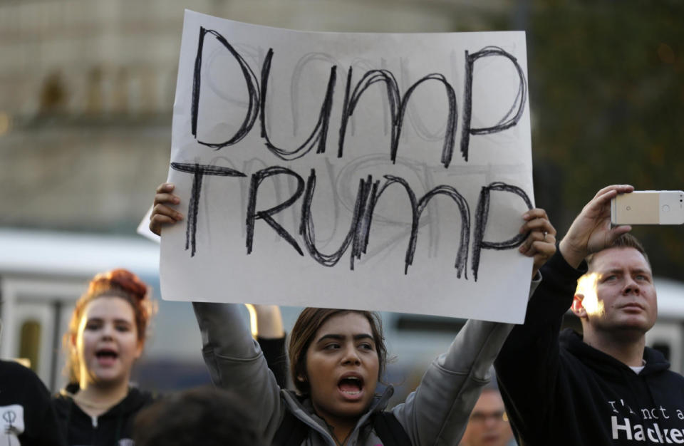 Una manifestante sostiene un letrero con la leyenda “Fuera Trump” mientras participa en una protesta en contra del presidente electo Donald Trump el miércoles 9 de noviembre de 2016 en el centro de Seattle. (AP Foto/Ted S. Warren)