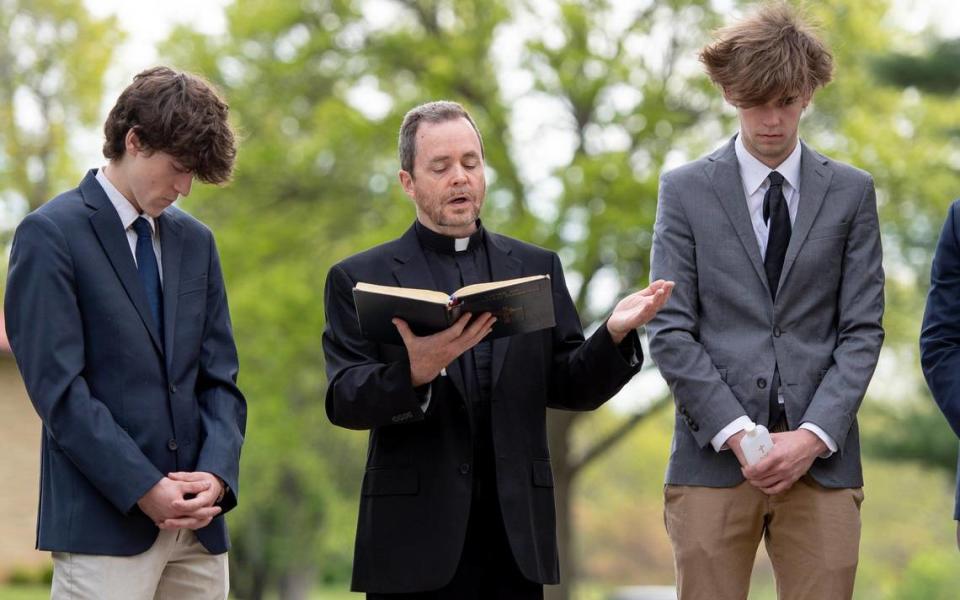 The Rev. Gary Menard reads from the Order of Christian Funerals during a May 4 service for unclaimed individuals at the Mount Olivet Catholic Cemetery in Raytown.