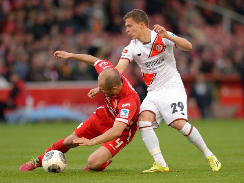 Der Cottbuser Ivica Banovic (l) kommt im Zweikampf mit Sebastian Maier zu Fall. Foto: Thomas Eisenhuth