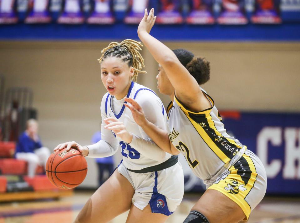 Christian Academy of Louisville's Mariah Knight tries to drive around Central's Shanese Carr in the first half of the Seventh District Kentucky high school girls quarterfinals on Feb. 27, 2023.