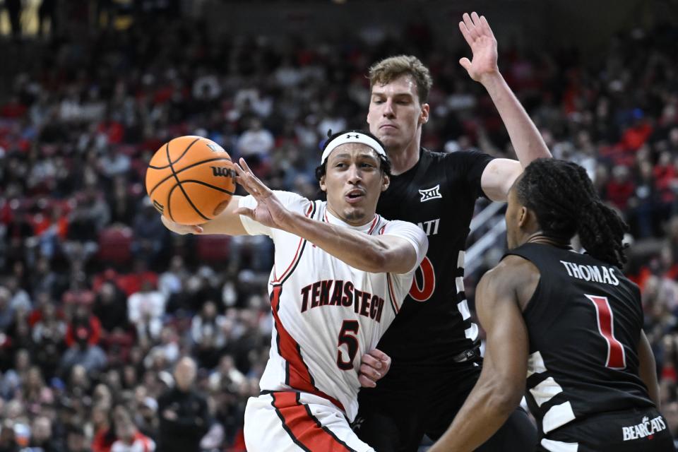 Texas Tech guard Darrion Williams (5) passes the ball against Cincinnati forward Viktor Lakhin, center, and guard Day Day Thomas (1) during the first half of an NCAA college basketball game, Saturday, Feb. 3, 2024, in Lubbock, Texas. (AP Photo/Justin Rex)