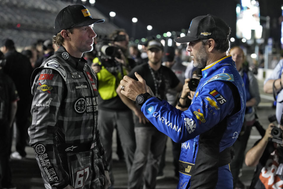 Jimmie Johnson, right, and Travis Pastrana talk before qualifying for the NASCAR Daytona 500 auto race Wednesday, Feb. 15, 2023, at Daytona International Speedway in Daytona Beach, Fla. (AP Photo/Chris O'Meara)