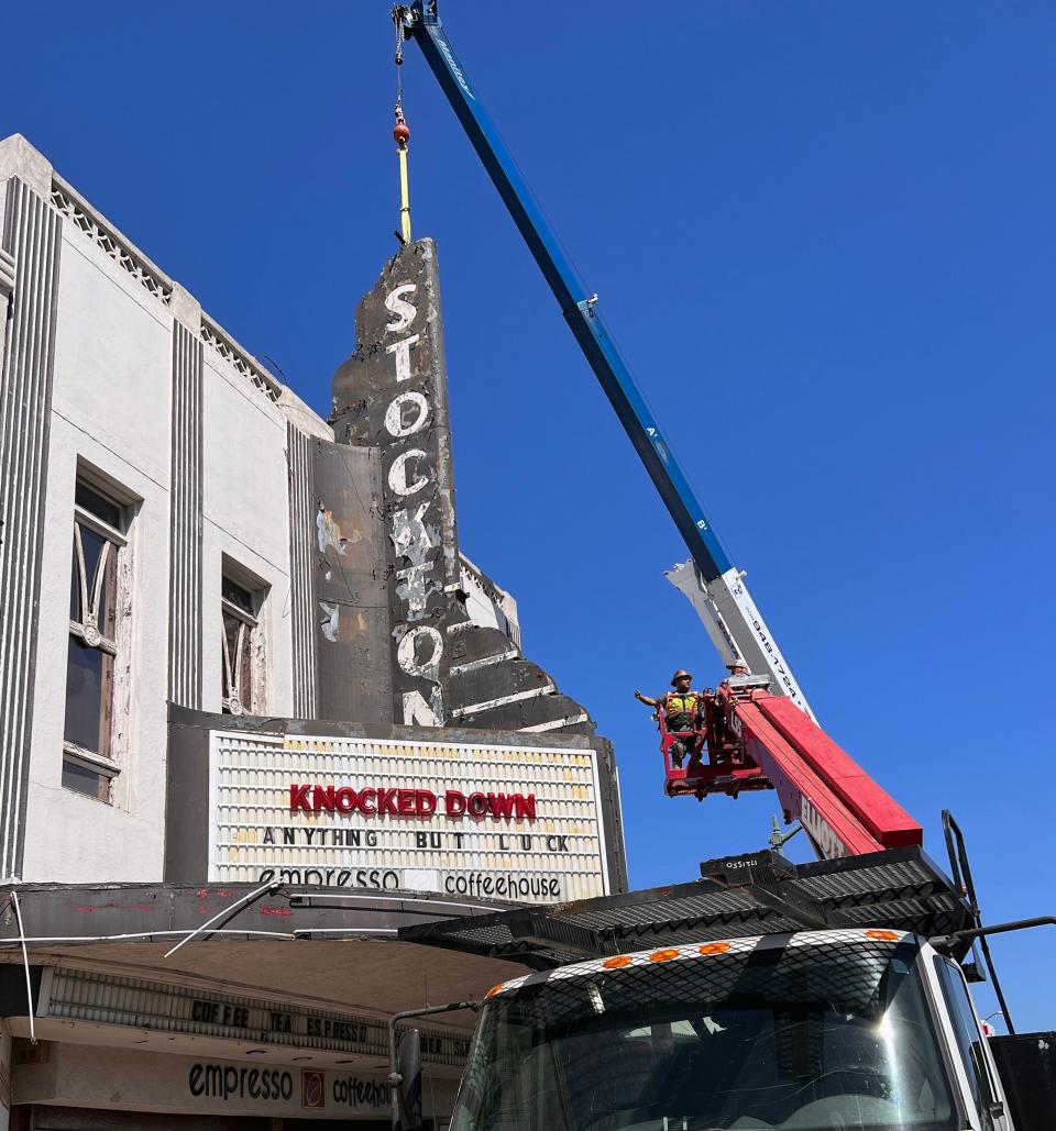 A crew with RB Environmental uses a crane to take down the sign at the Empire Theater on Pacific Avenue along the Miracle Mile in Stockton on Aug. 2, 2023. According to Ronald J. Barber III vice president of RB Environmental doing the demolition, the plan is to do demolition of the fire-damaged building and the renovate it. The sign is supposed to be used in the refurbished site.