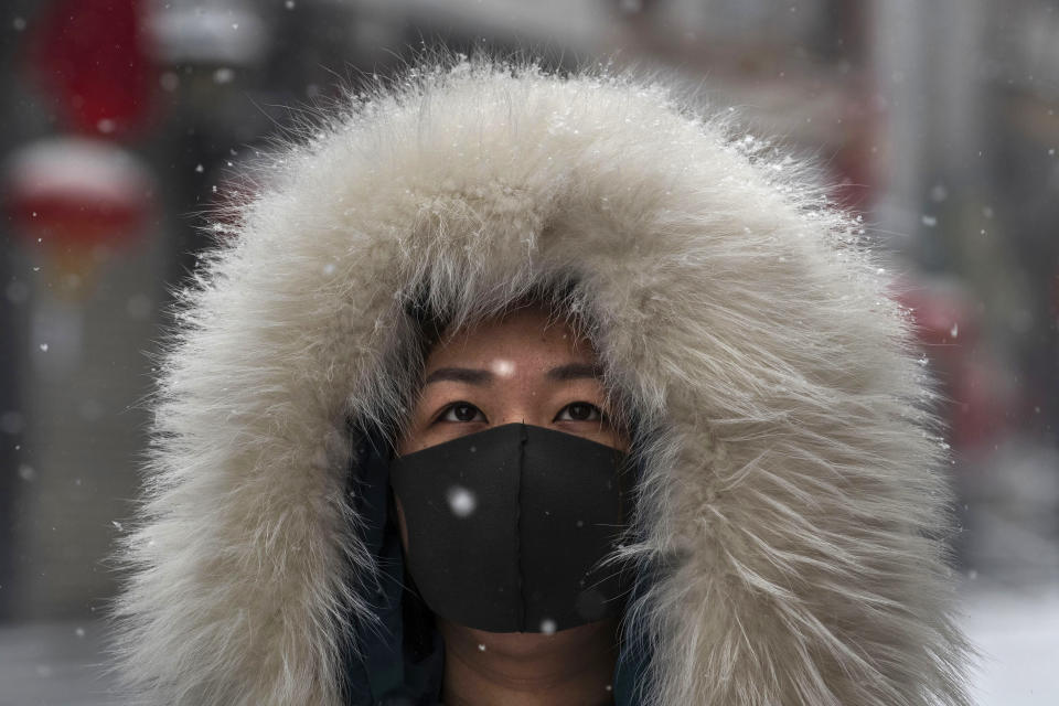 BEIJING, CHINA - FEBRUARY 05: A Chinese woman wears a protective mask as she walks during a snowfall in an empty and shuttered commercial street on February 5, 2020 in Beijing, China. China's stock markets tumbled in trading on Monday, the first day back after an extended Lunar New Year holiday as a mystery virus continues to spread in China and worldwide. The number of cases of a deadly new coronavirus rose to more than 20000 in mainland China Wednesday, days after the World Health Organization (WHO) declared the outbreak a global public health emergency. China continued to lock down the city of Wuhan in an effort to contain the spread of the pneumonia-like disease which medicals experts have confirmed can be passed from human to human. In an unprecedented move, Chinese authorities have put travel restrictions on the city which is the epicentre of the virus and neighbouring municipalities affecting tens of millions of people. The number of those who have died from the virus in China climbed to over 490 on Thursday, mostly in Hubei province, and cases have been reported in other countries including the United States, Canada, Australia, Japan, South Korea, India, the United Kingdom, Germany, France and several others. The World Health Organization has warned all governments to be on alert and screening has been stepped up at airports around the world. Some countries, including the United States,  have put restrictions on Chinese travellers entering and advised their citizens against travel to China. (Photo by Kevin Frayer/Getty Images)