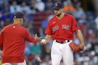 Boston Red Sox starting pitcher Nathan Eovaldi, right, hands the ball to manager Alex Cora during the second inning of the team's baseball game against the Houston Astros at Fenway Park, Tuesday, May 17, 2022, in Boston. Eovaldi allowed nine runs, six earned, in the second inning. (AP Photo/Charles Krupa)