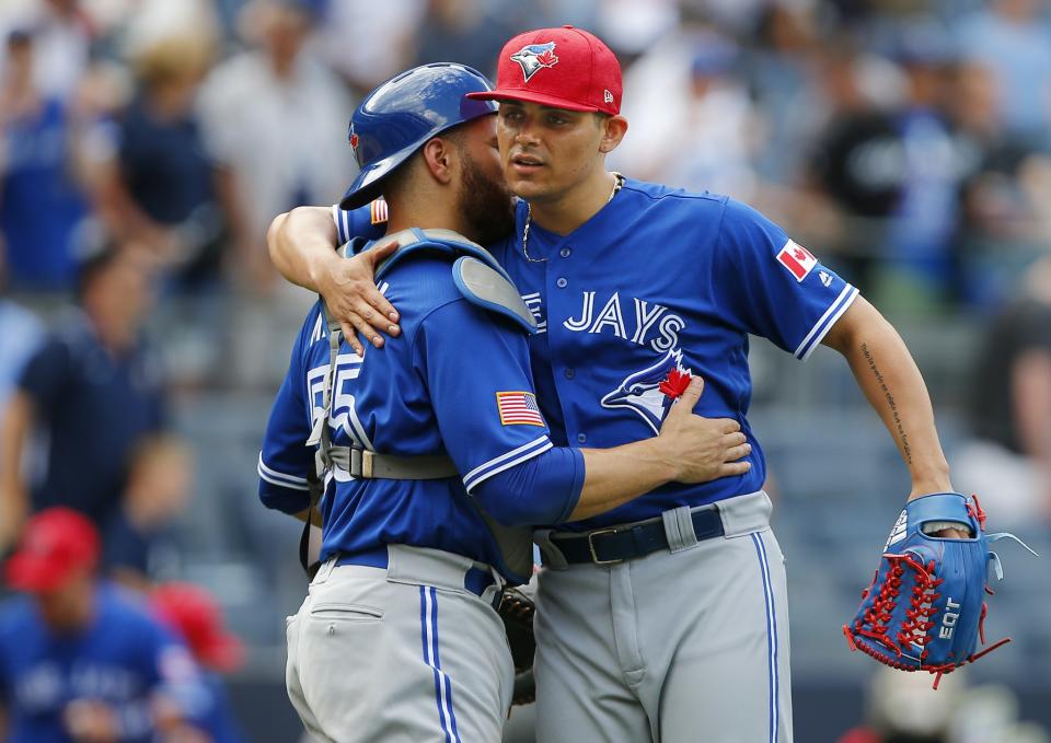 Catcher Russell Martin #55 of the Toronto Blue Jays and closer Roberto Osuna #54 embrace after their 4-1 win over the New York Yankees during a game at Yankee Stadium on July 4, 2017 in the Bronx borough of New York City.