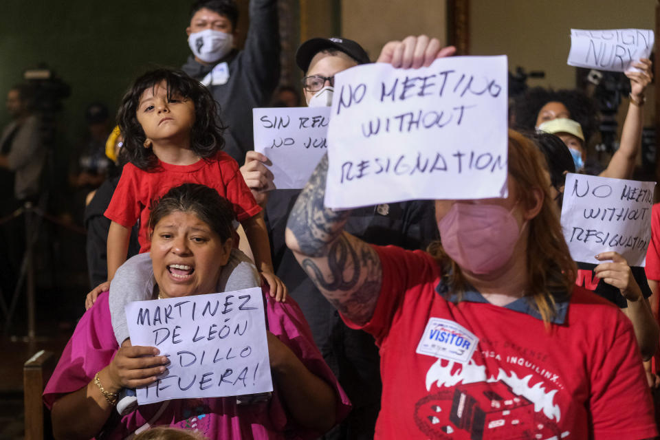 Kenia Alcocer carrying her son Genaro protest before the cancellation of the Los Angeles City Council meeting Wednesday, Oct. 12, 2022 in Los Angeles. (AP Photo/Ringo H.W. Chiu)