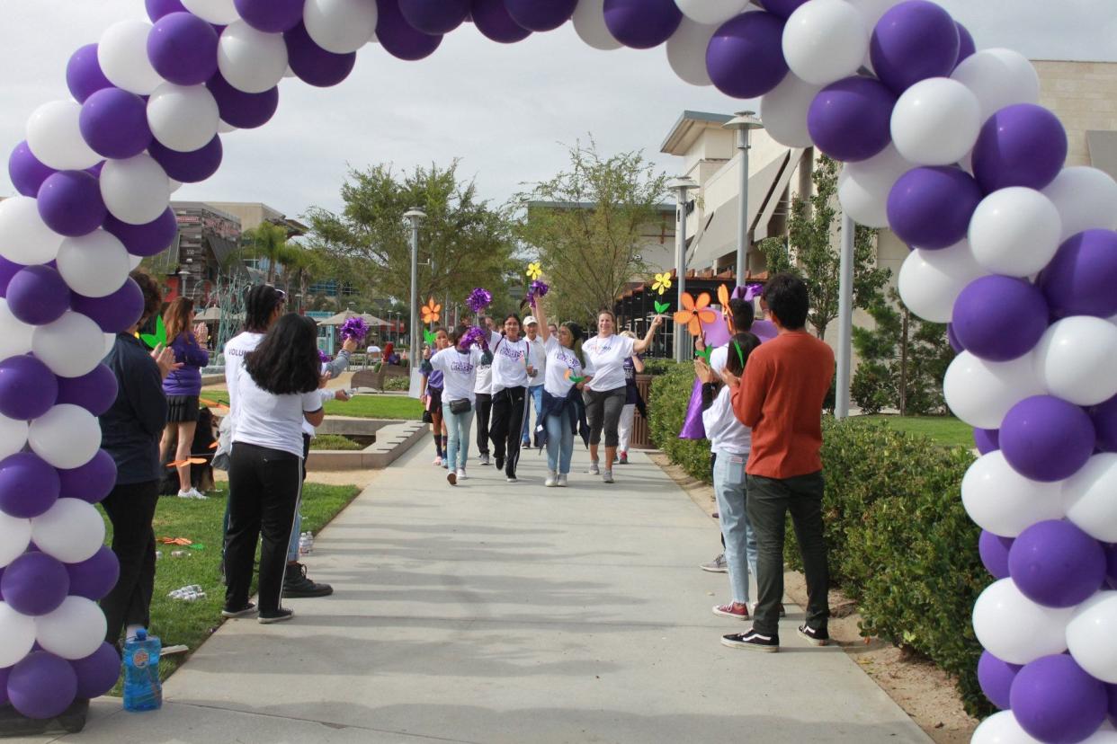 Participants in the 2019 West Ventura County Walk to End Alzheimer’s make their way toward the finish line as bystanders applaud. This year's event is scheduled for 9 a.m. on Saturday at The Collection in Oxnard.