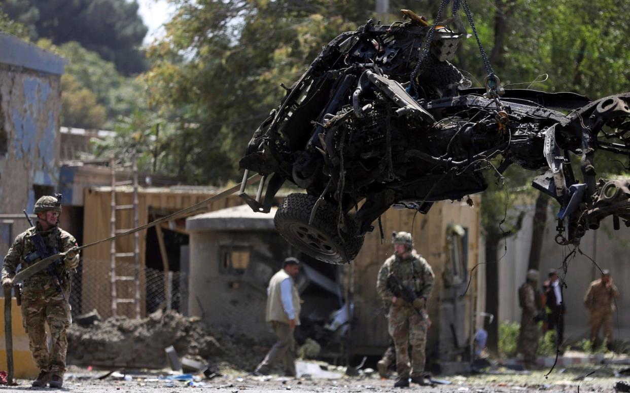 Troops from NATO Resolute Support remove a blown-up vehicle in Kabul last week - AP