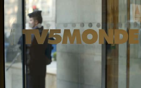 A French police officer stands guard in front of the main entrance of French television network TV5Monde headquarters in Paris, April 9, 2015. REUTERS/Benoit Tessier