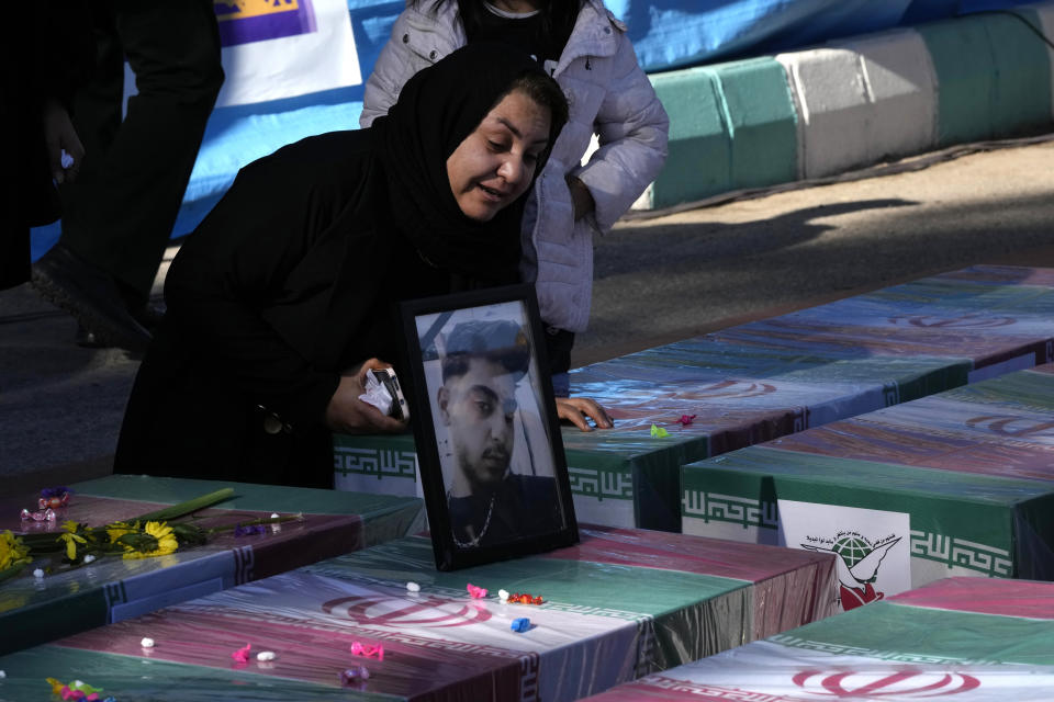 A woman mourns over the flag-draped coffin of her son who was killed in Wednesday's bomb explosion, during the victims funeral ceremony in the city of Kerman about 510 miles (820 km) southeast of the capital Tehran, Iran, Friday, Jan. 5, 2024. Iran on Friday mourned those slain in an Islamic State group-claimed suicide bombing targeting a commemoration for a general slain in a U.S. drone strike in 2020. (AP Photo/Vahid Salemi)