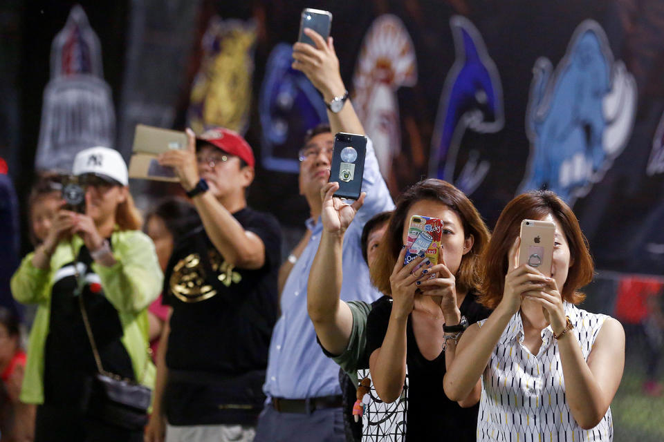 <p>Friends and relatives take pictures a Future League American football youth league match between the Sharklets and the Eagles in Beijing, May 26, 2017. (Photo: Thomas Peter/Reuters) </p>