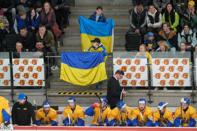 Ukraine fans hold up flags during an ice hockey match against Japan in Estonia (REUTERS)