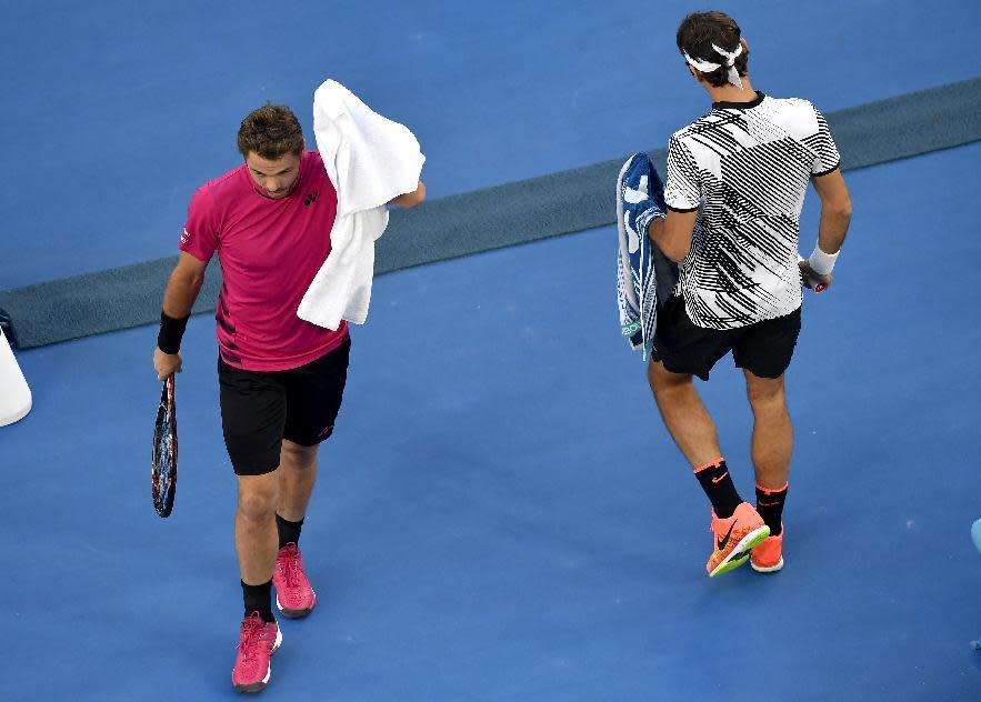 Switzerland's Stan Wawrinka, left, walks past compatriot Roger Federer during their semifinal at the Australian Open tennis championships in Melbourne, Australia, Thursday, Jan. 26, 2017. (AP Photo/Andy Brownbill)