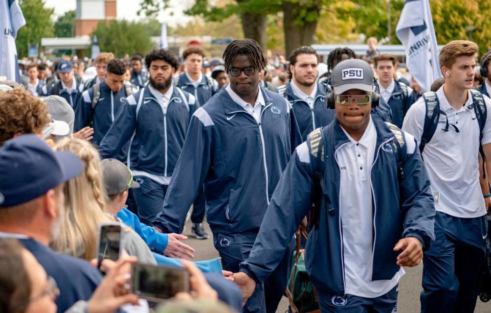 Penn State football players high five fans as they arrive at Beaver Stadium for the game on Saturday, Sept. 24, 2022.