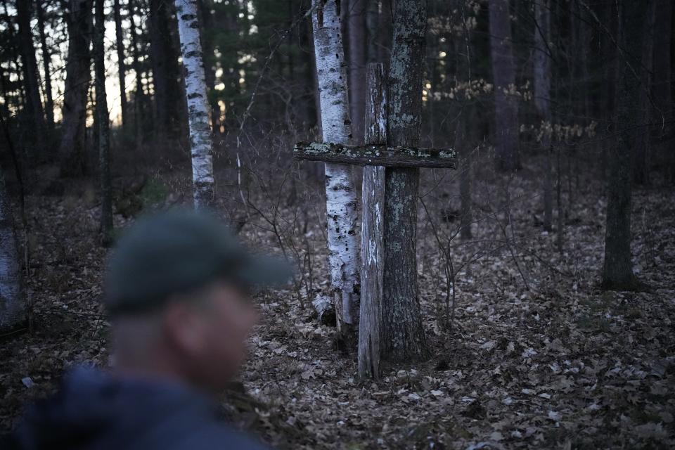 John Baker stands near a cross that he and his father erected to mark the location where a church used to stand near the Chippewa Flowage on the Lac Courte Oreilles Reservation, Sunday, April 14, 2024, near Hayward, Wis. The former church was moved when a local power company created the flowage by building the Winter Dam in the 1920s. (AP Photo/John Locher)