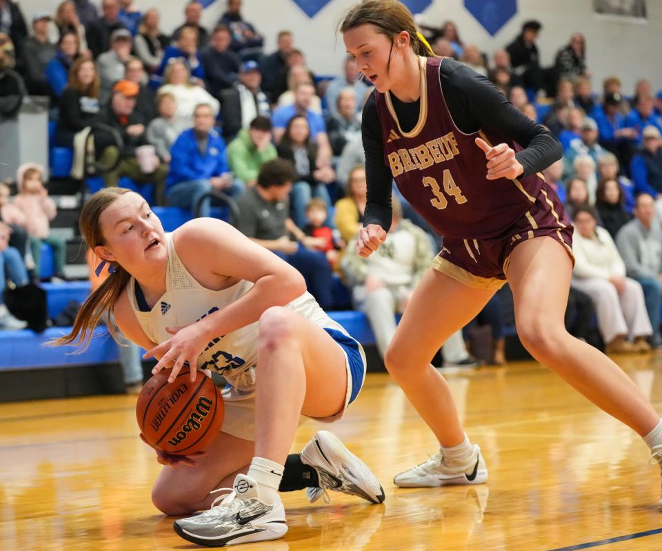 Bishop Chatard Trojans Annie McAllister (33) searches to pass the ball against Brebeuf Jesuit's guard Jailen Bowling (34) on Tuesday, Jan. 30, 2024, during the game at Bishop Chatard High School in Indianapolis.