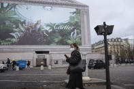 A woman wearing a face mask to protect against coronavirus walks in Paris, Tuesday, Nov. 30 2021. The emergence of the new COVID-19 omicron variant and the world's desperate and likely futile attempts to keep it at bay are reminders of what scientists have warned for months: The coronavirus will thrive as long as vast parts of the world lack vaccines.. (AP Photo/Lewis Joly)