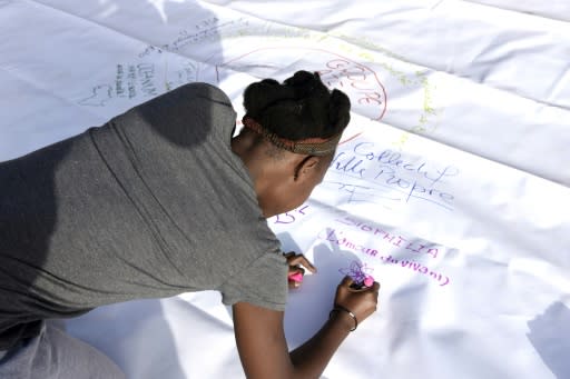 A volunteer signs a poster