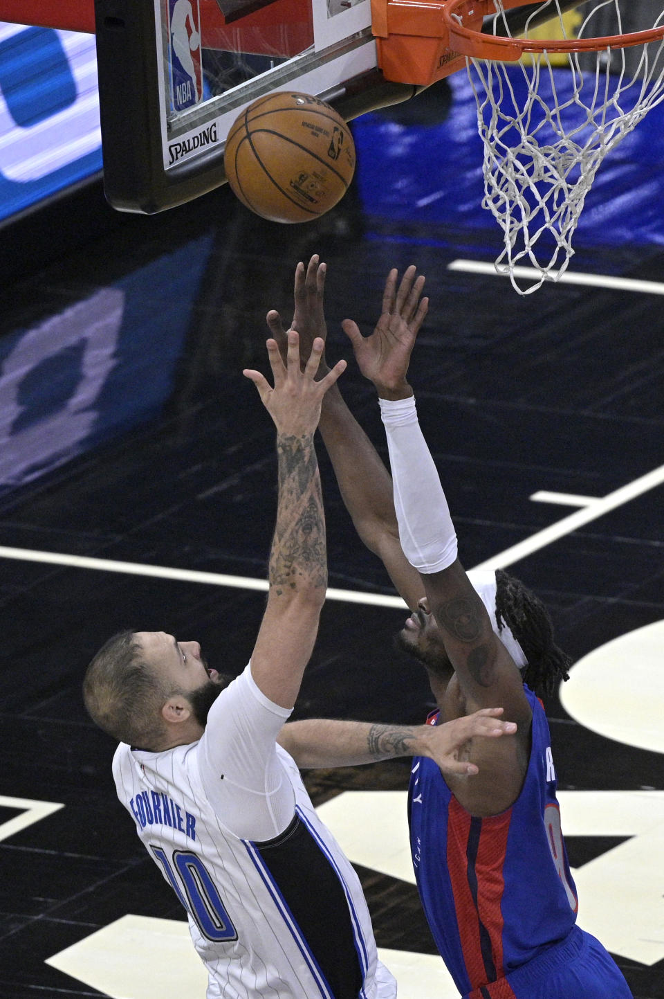 Orlando Magic guard Evan Fournier, left, is fouled by Detroit Pistons forward Jerami Grant, right, while going up for a shot during the first half of an NBA basketball game, Tuesday, Feb. 23, 2021, in Orlando, Fla. (AP Photo/Phelan M. Ebenhack)