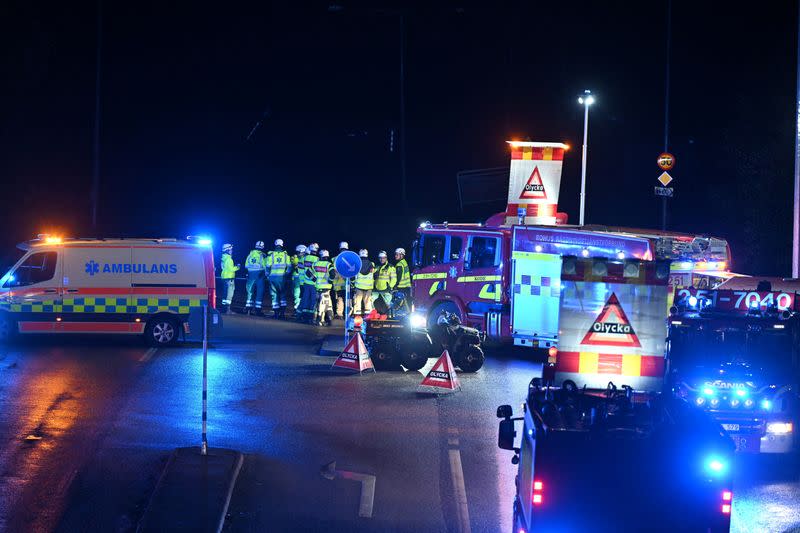 Workers stand near emergency vehicles following a landslide, near Stenungsund