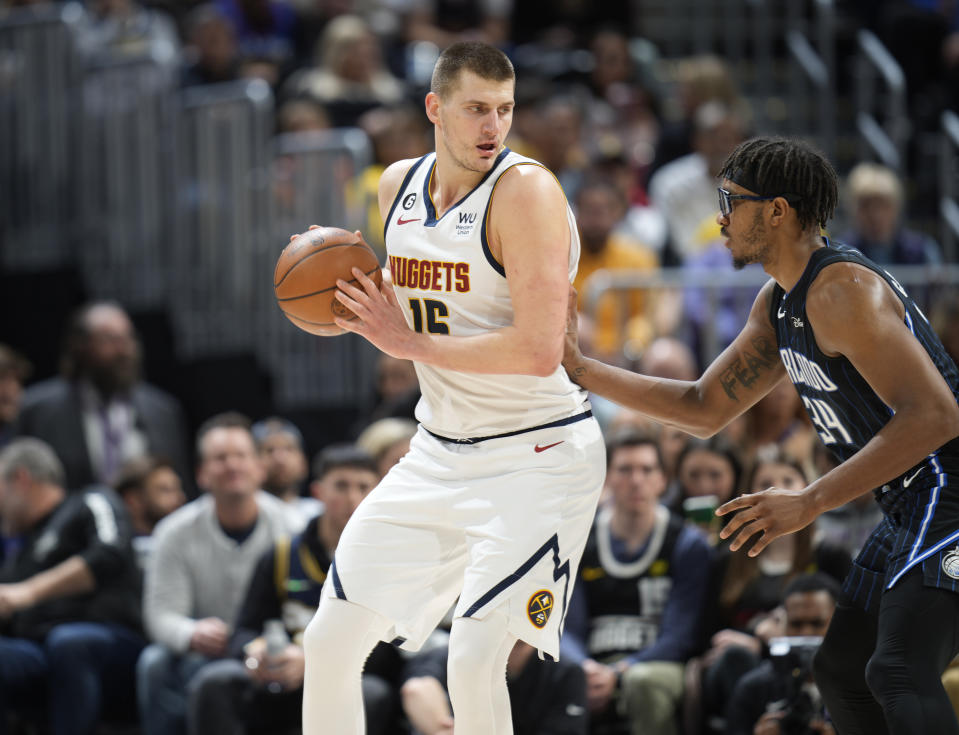 Denver Nuggets center Nikola Jokic, left, looks to drive to the basket as Orlando Magic center Wendell Carter Jr. defends in the first half of an NBA basketball game Sunday, Jan. 15, 2023, in Denver. (AP Photo/David Zalubowski)