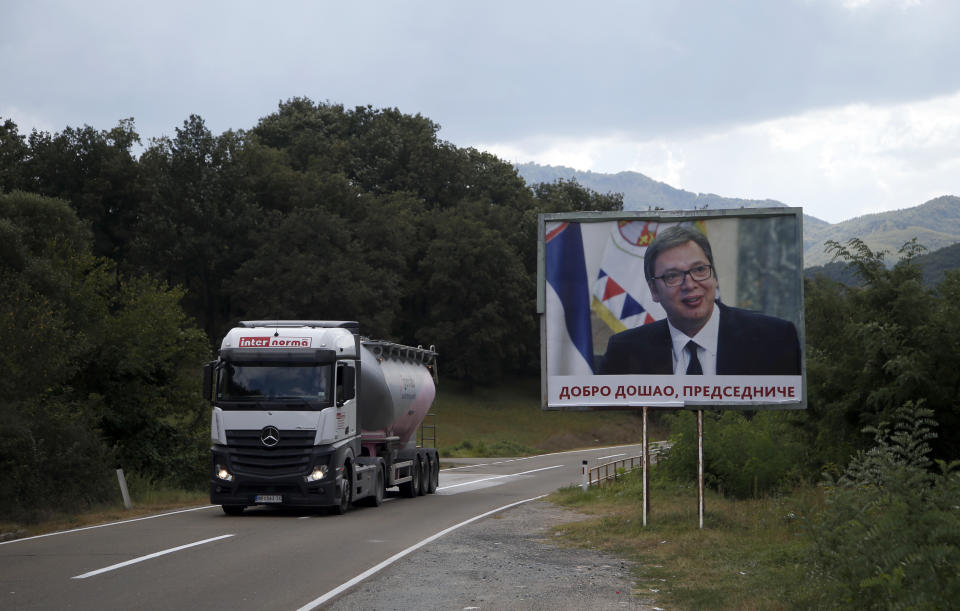 In this Sept. 7, 2018 file photo, a truck passes by a billboard that reads: '"Welcome, President" and shows Serbian President Aleksandar Vucic, near village of Lesak in northern Kosovo. Kosovo's government has decided to introduce a 100 percent import tax on all goods imported from Serbia and Bosnia Herzegovina. (AP Photo/Darko Vojinovic, File)