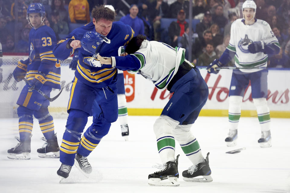Buffalo Sabres defenseman Erik Johnson (6) and Vancouver Canucks center J.T. Miller, front right, fight during the first period of an NHL hockey game Saturday, Jan. 13, 2024, in Buffalo, N.Y. (AP Photo/Jeffrey T. Barnes)