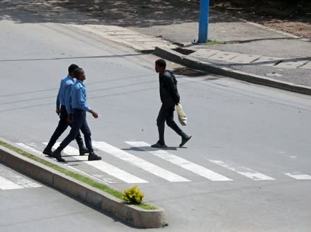 Security officers walk on a zebra-crossing as they patrol on the street during a clash between a Sidama youth and a securities after they declared their own region in Hawassa