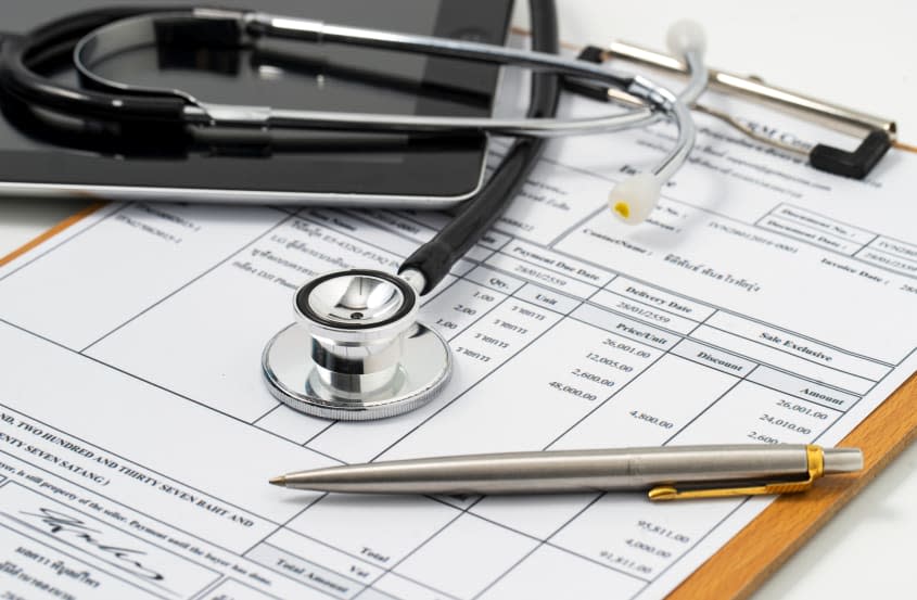 Stethoscope on medical billing statement on table